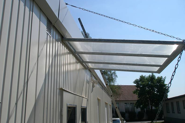 Vordach aus einem Stahlrahmen und einer Plexiglaseindeckung verstärkt mit Ketten